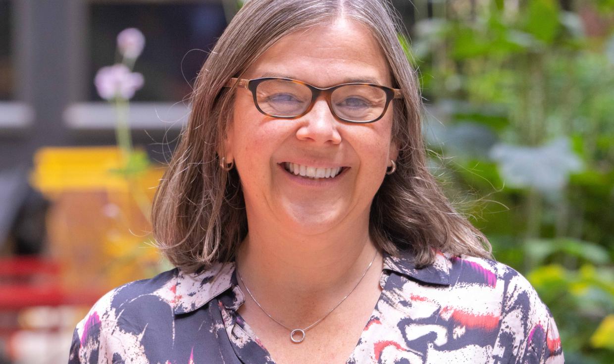 Headshot of Stephanie Newton, smiling to camera in outdoor setting. 