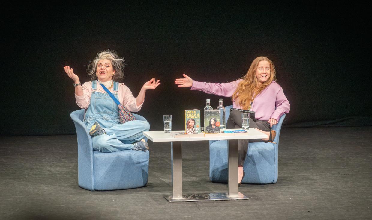 Caitlin Moran and host sat on stage, with welcoming expressions.